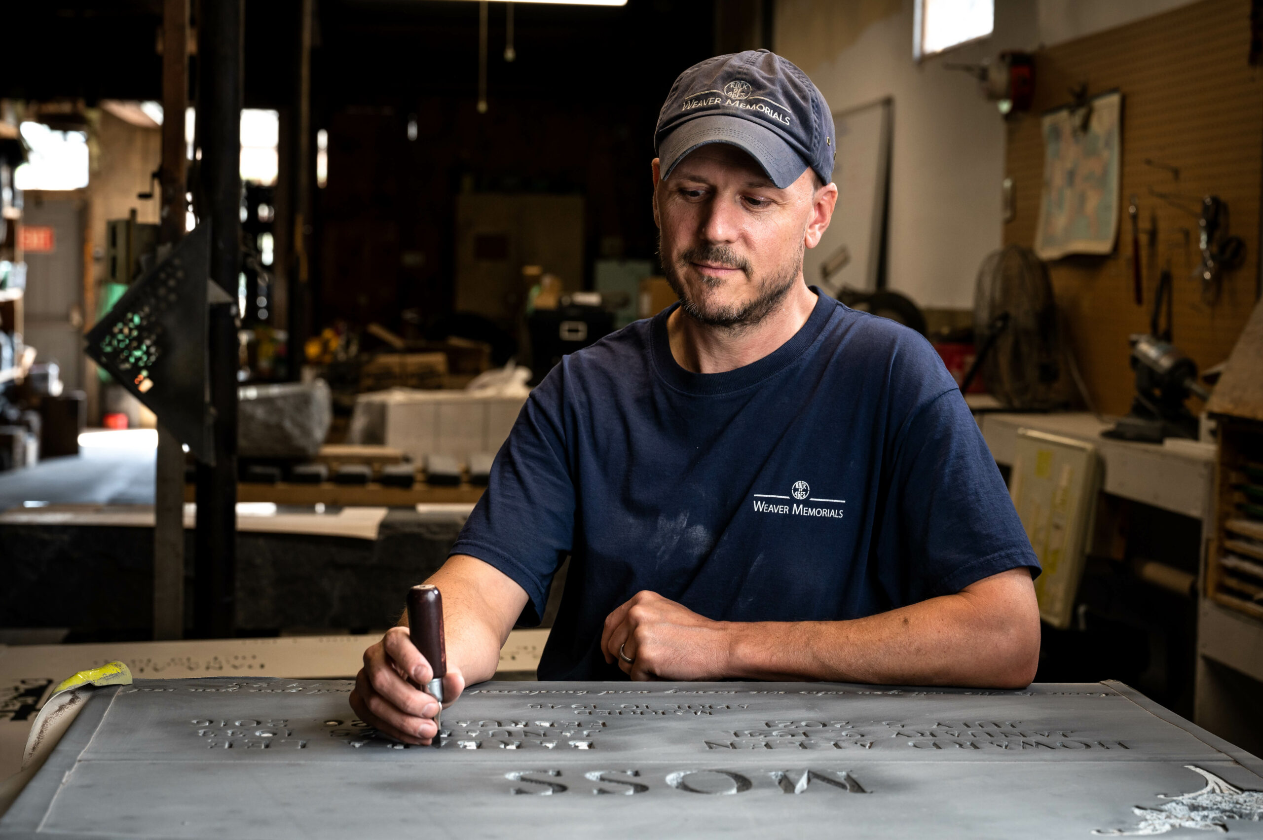 Consierge page 1 Artisan engraving a headstone.